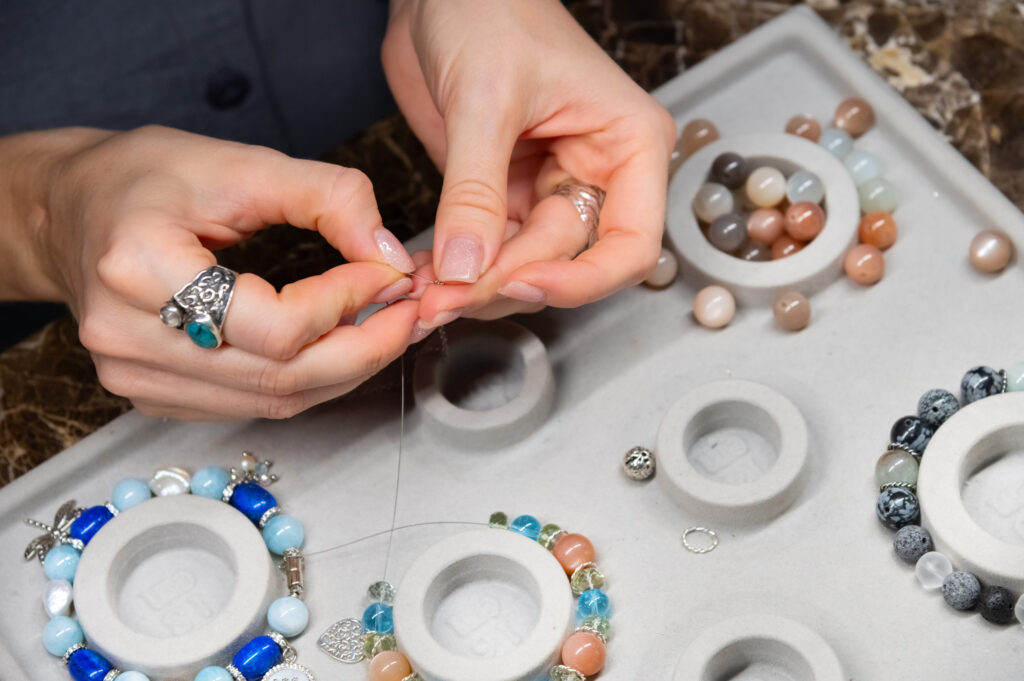Professional jewelry designer making handmade jewelry in studio workshop close up. Fashion, creativity and handmade concept.
