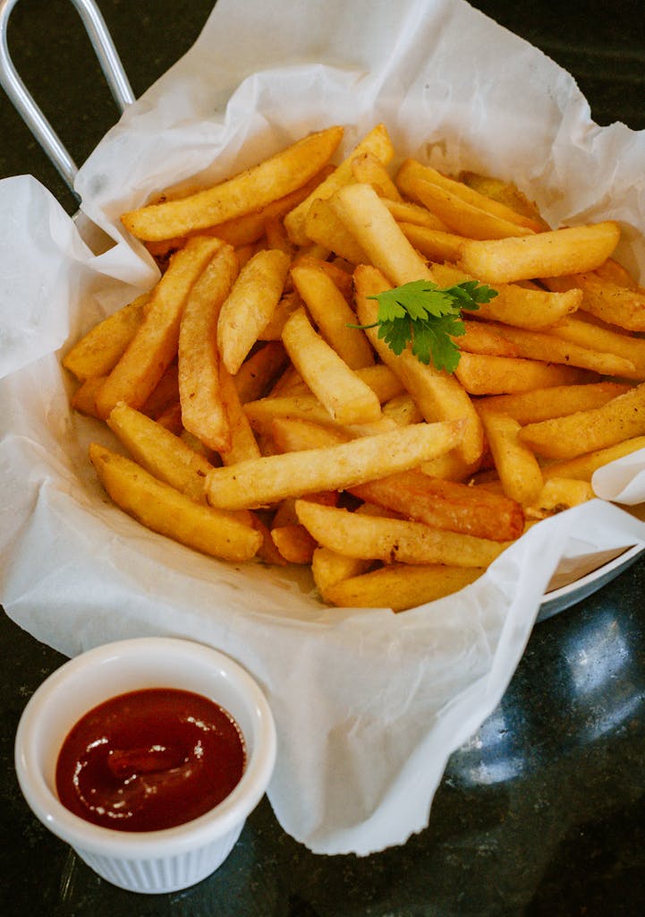 Delicious crispy french fries served with tangy ketchup on the side.