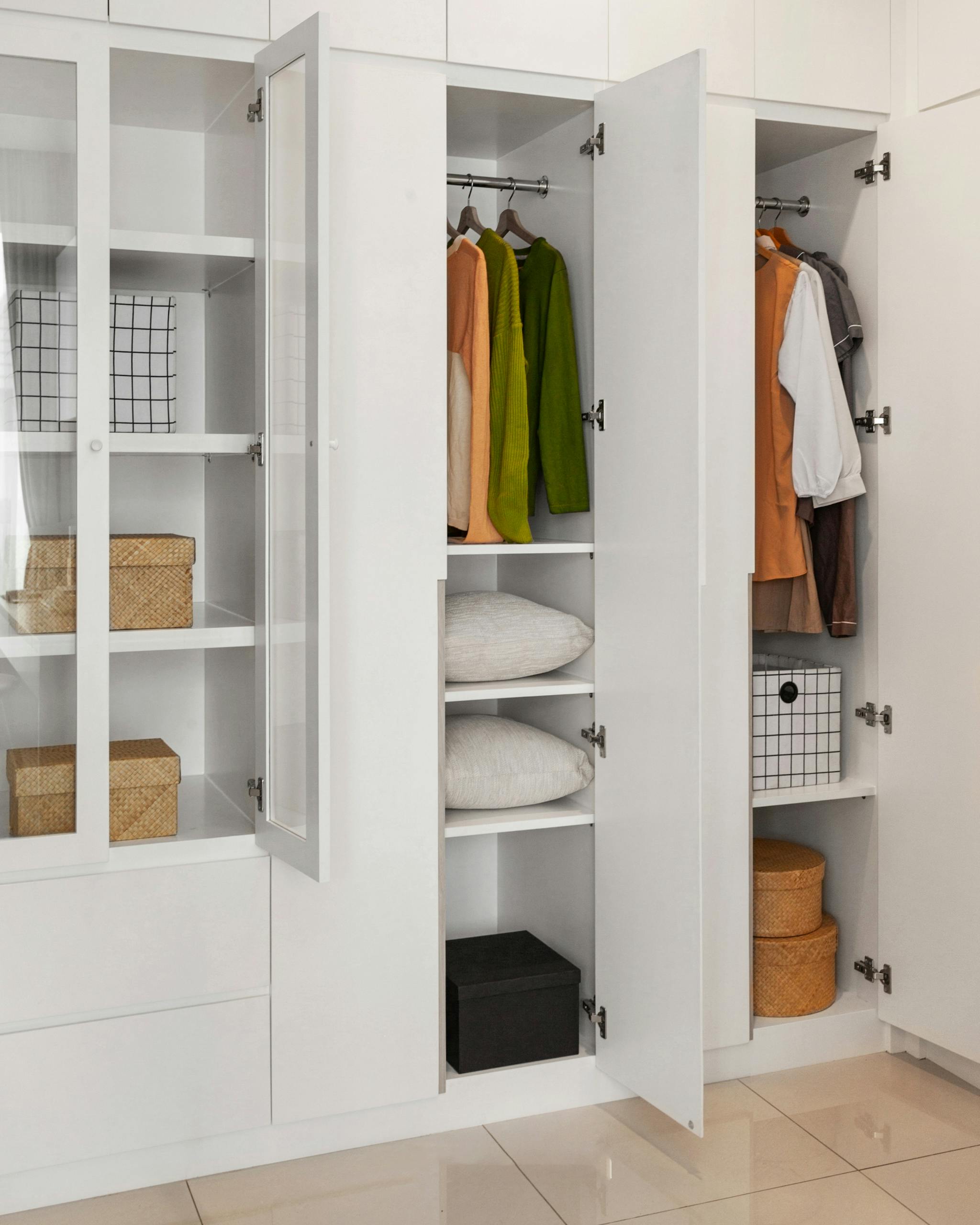 Modern minimalist wardrobe with organized clothes and storage solutions, showcasing a sleek interior design.
