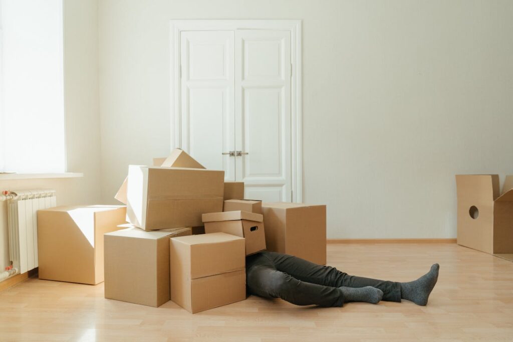 person-in-black-leather-boots-lying-on-brown-cardboard-boxes-
