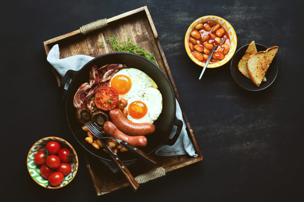 Traditional English breakfast in a cast iron pan, view from above on rustic style table setting