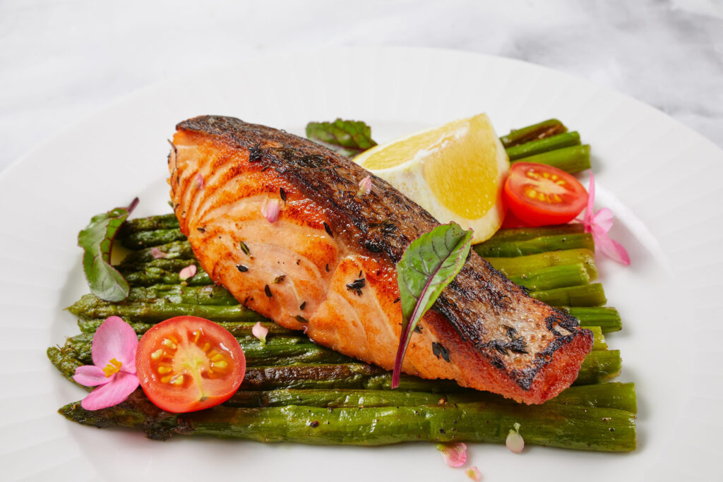 baked red fish with vegetables, lemon, tomatoes, asparagus beans, with spices and herbs