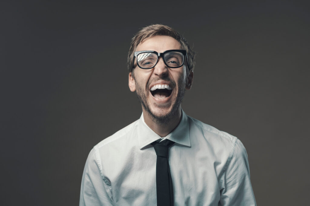 Young businessman laughing out loud and staring at camera