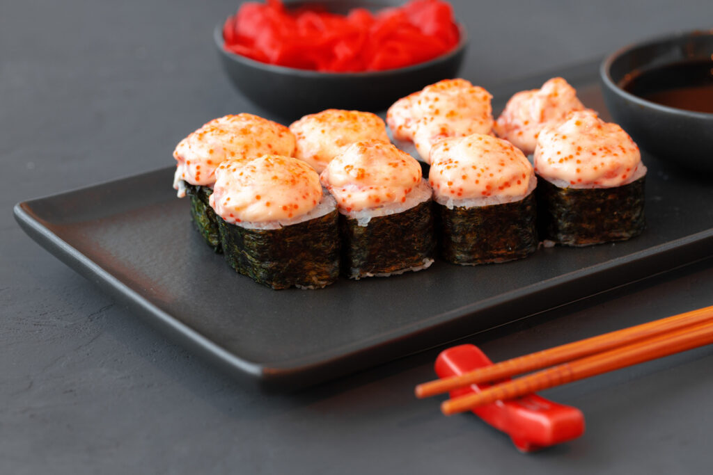 10 Foods That Could Make You Seriously Sick After Expiration 5 Baked sushi roll served on black plate on wooden table