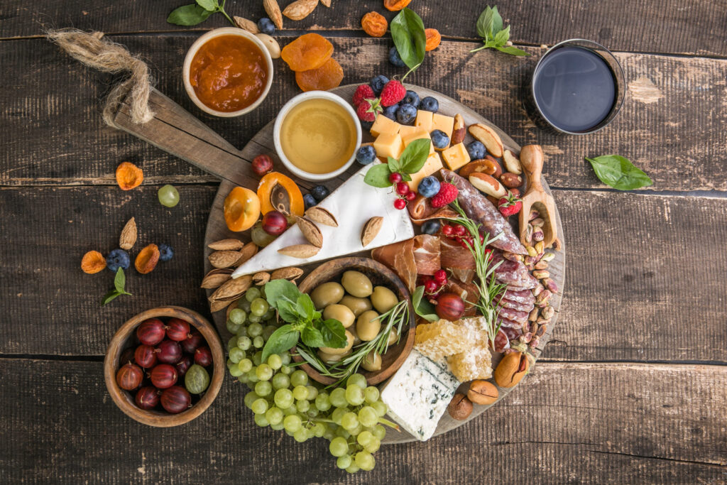 Antipasto background. Different Italian snacks with fruit, nut on a rustic background.