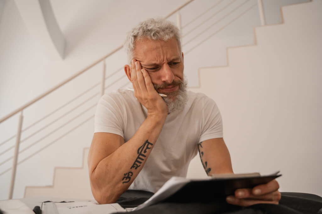 Sad designer looking at clipboard in studio