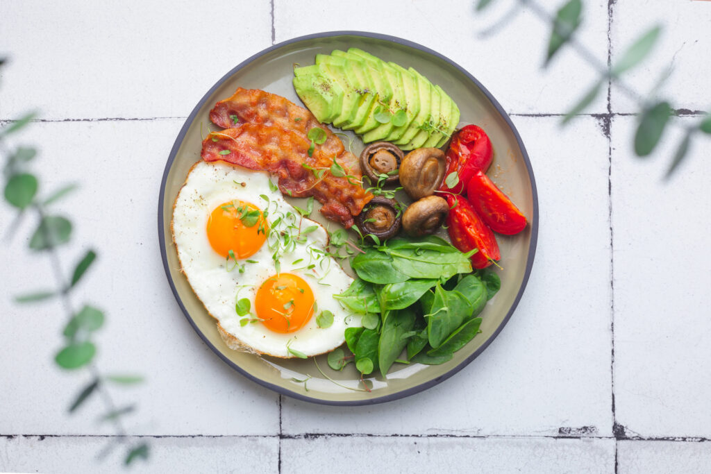 Healthy keto breakfast with egg, avocado, cheese and bacon