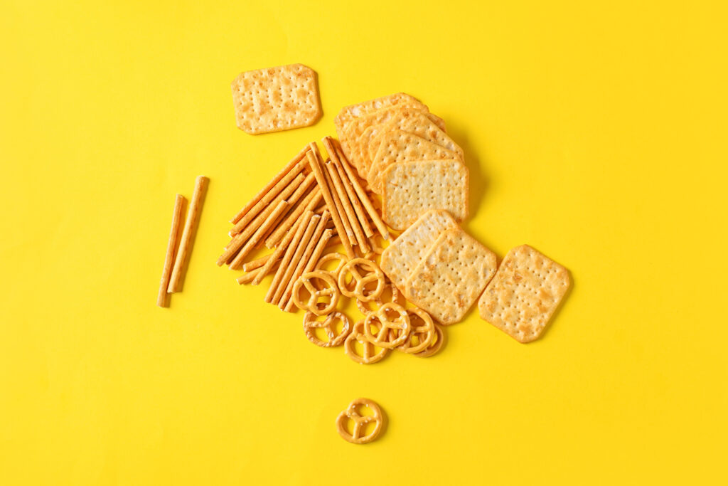Tasty different crackers on color background