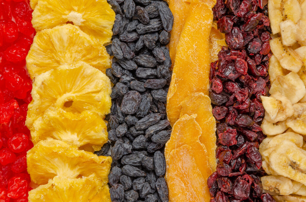Mix dried fruit rows of apricots, cherries, pineapples, raisins, mangoes and cranberries. Healthy food background. Top view, close up