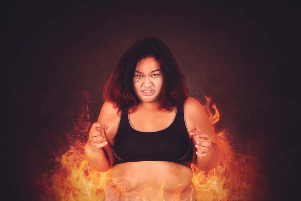 Fat young woman feeling passionate to get weight loss while standing with fire