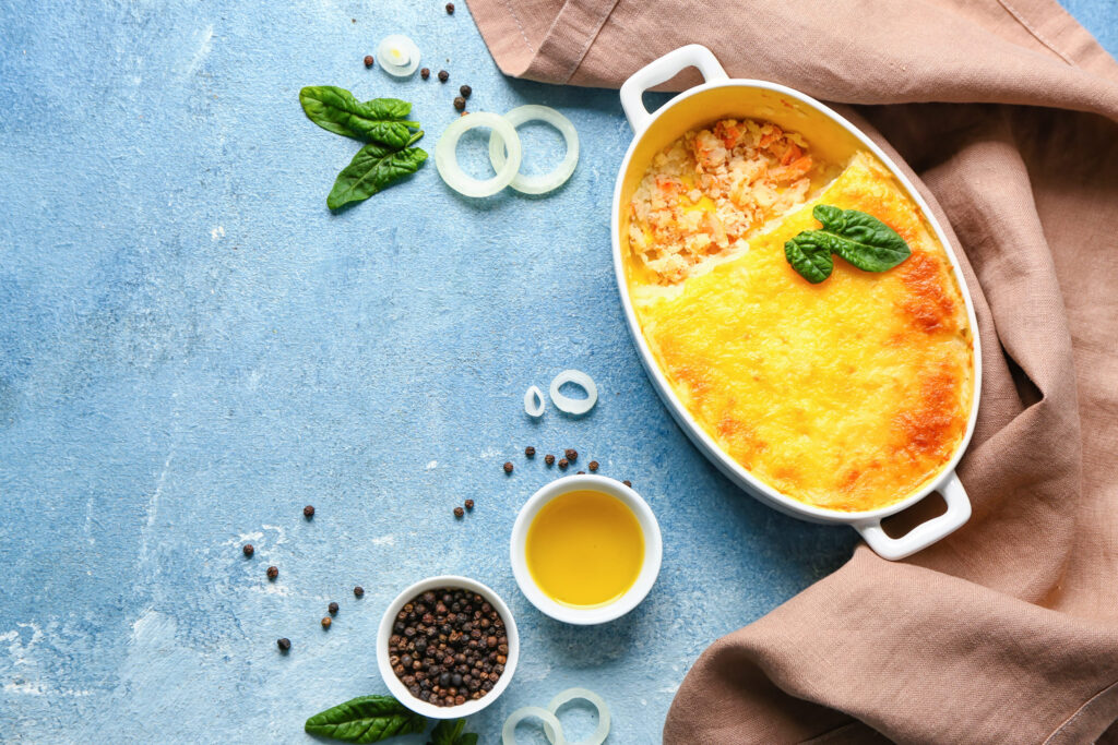 Baking dish with tasty English fish pie on blue background