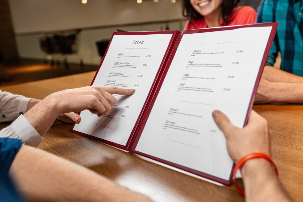 close up of couple with menu at restaurant