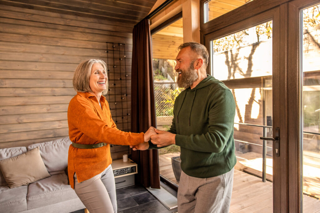 Active couple. Happy couple dancing at home and looking energized and excited