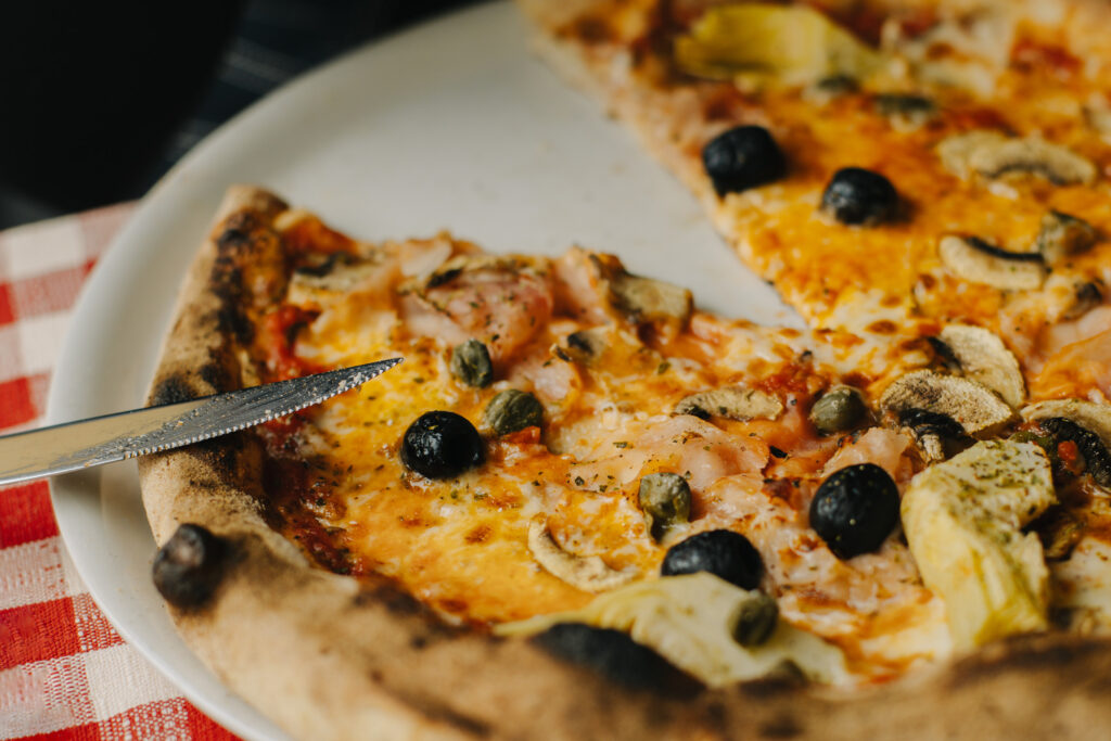 Delicious pizza Margarita in a traditional Italian pizzeria. Selective focus. Close-up.