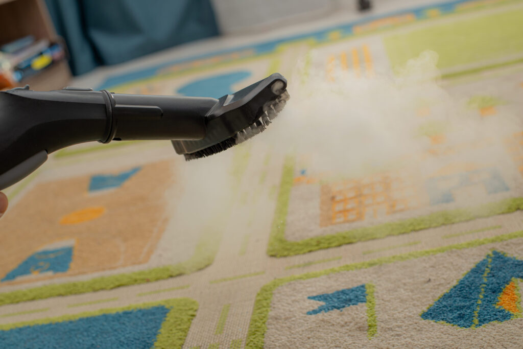 Selective focus of vacuum cleaner with hot steam on carpet at home