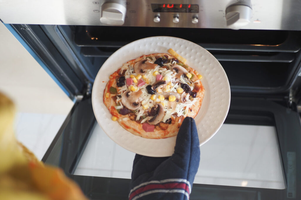When baking a homemade pizza in the oven, ensure safety by wearing a protective glove on your hand