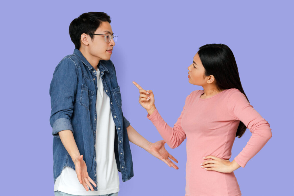 Asian angry girl scolding her surprised boyfriend