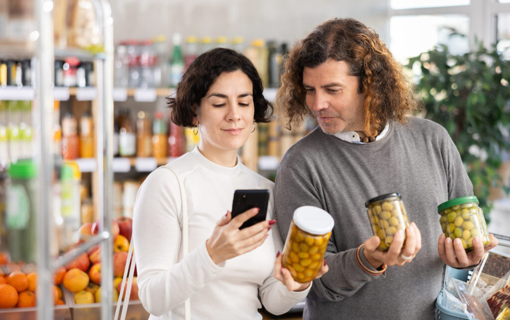 Couple scanning olives on mobile phone