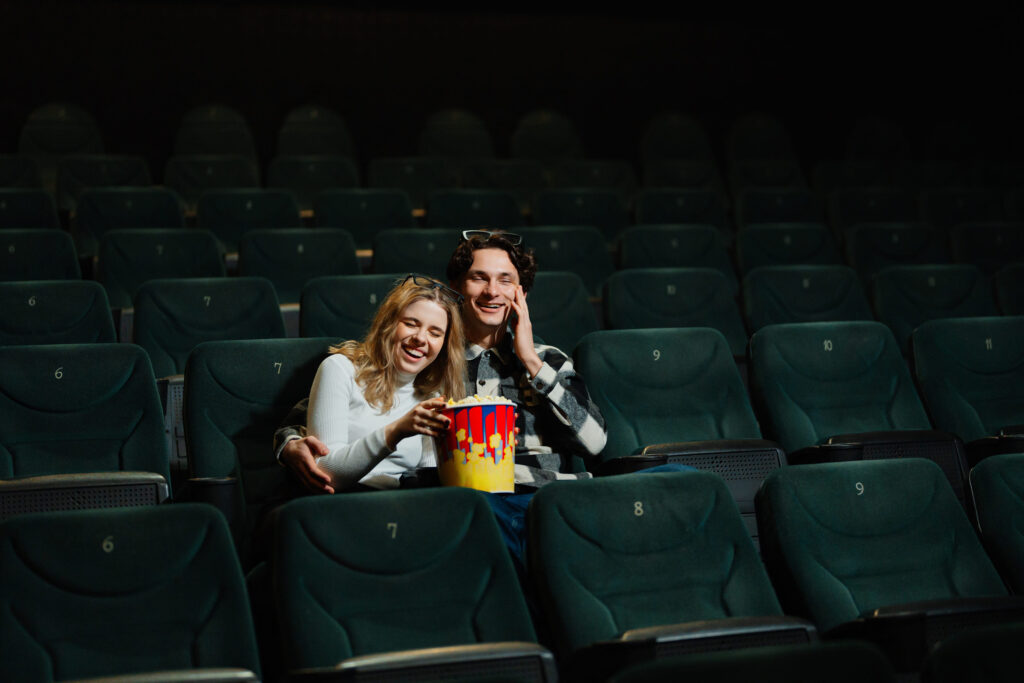 Young couple enjoying a movie together in a nearly empty theater