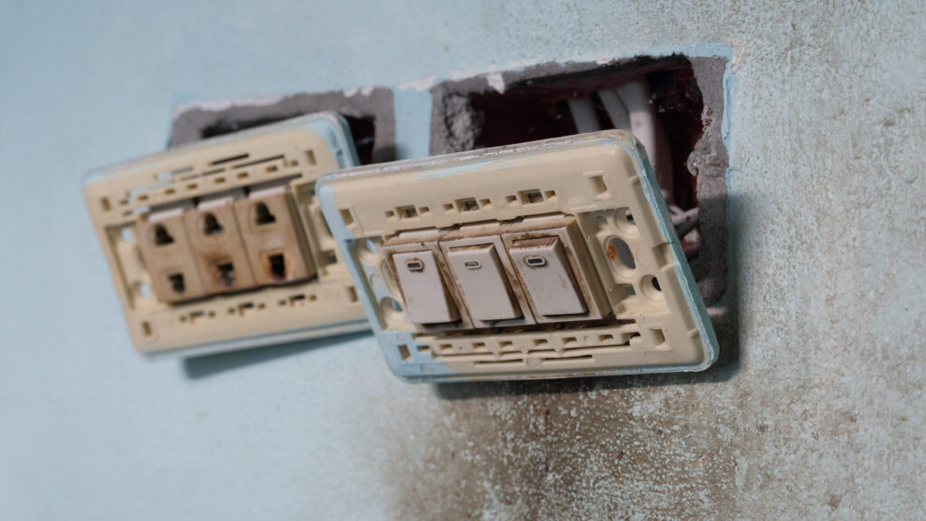 Three push button light switches are removed from their wall-mounted mounting blocks. They are removed for maintenance or replacement with newer models.