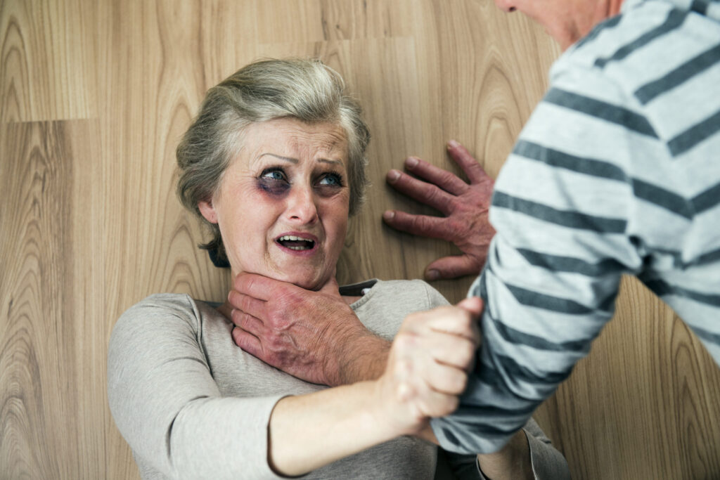 Woman victim of domestic violence and abuse  Mature woman with black eye scared of a man with a belt
