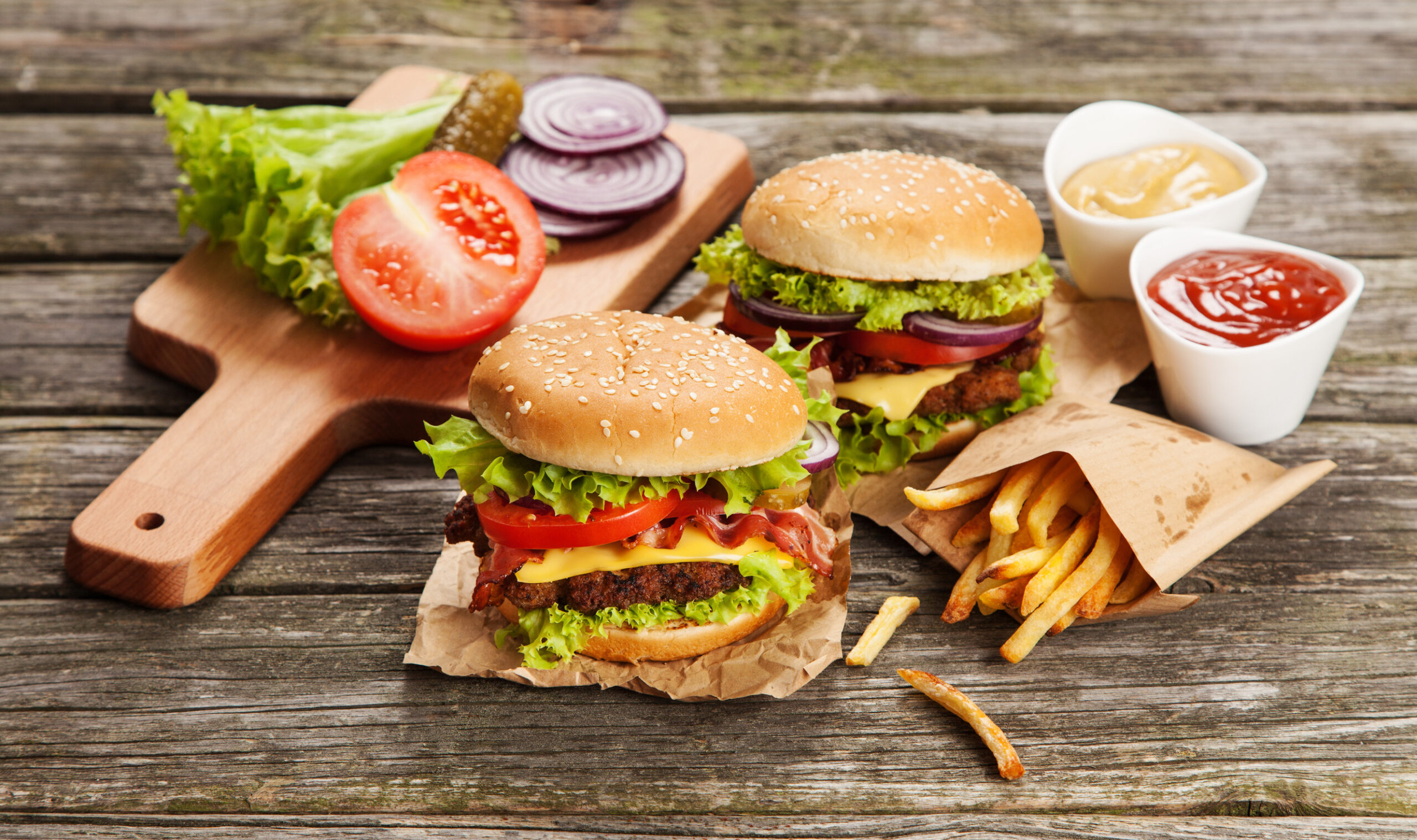 Delicious hamburger and french fries on wooden background
