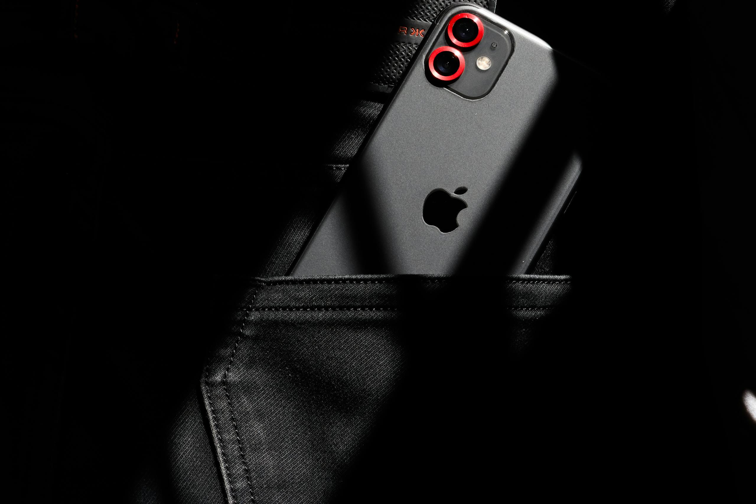 A close-up image of a smartphone partially visible in a black jeans pocket, showcasing modern gadget aesthetics.