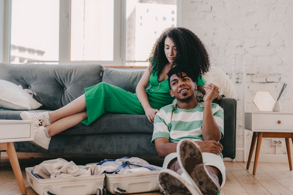 A couple enjoying leisure time at home, with a packed suitcase on the floor.