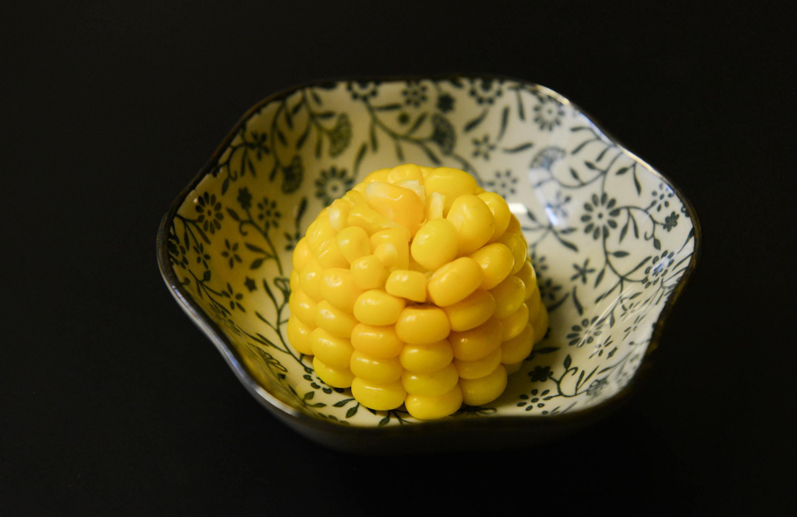 A decorative bowl with a portion of sweet yellow corn, ideal for healthy eating visuals.