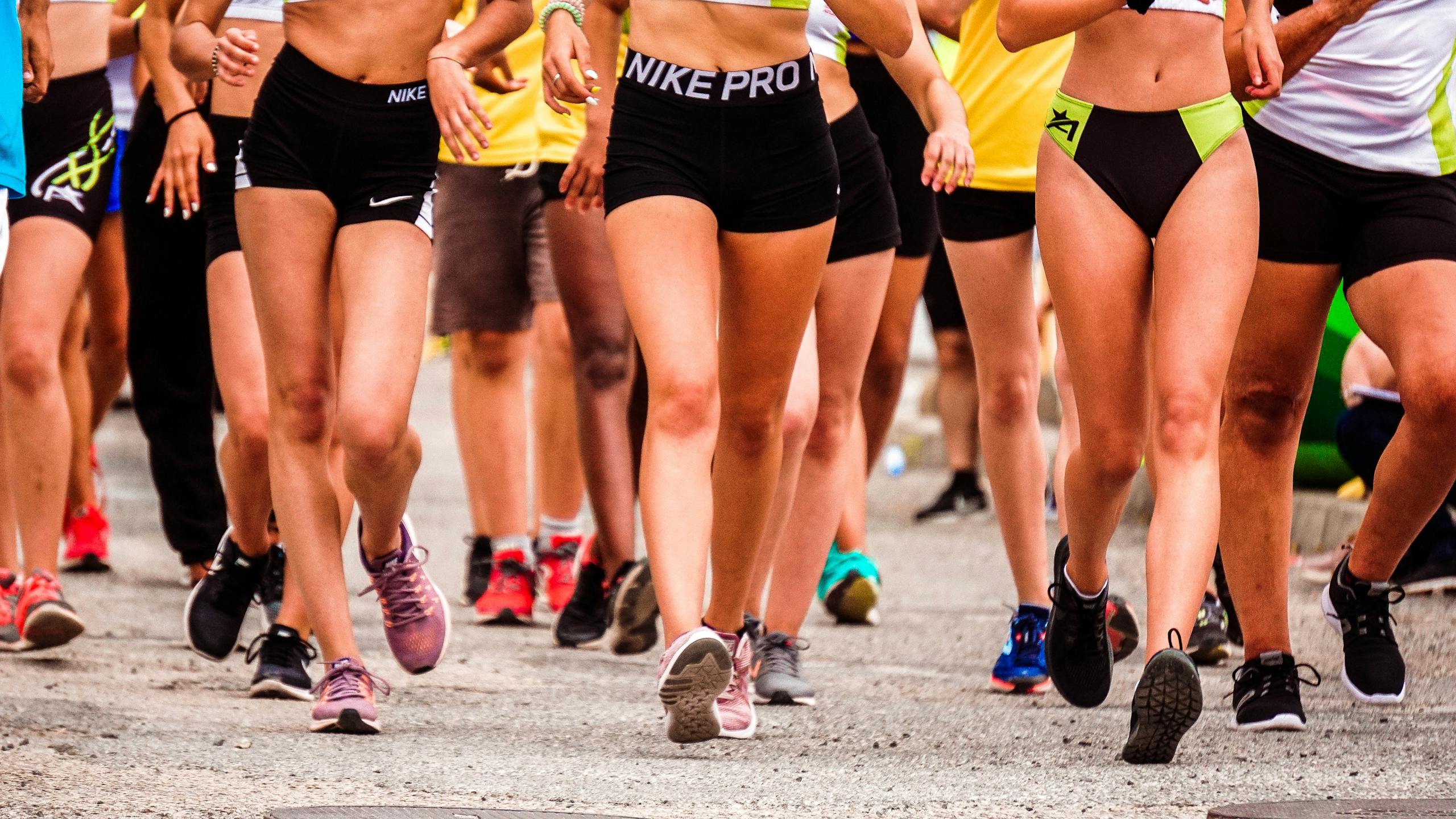 A group of runners participating in an outdoor street marathon wearing athletic gear.