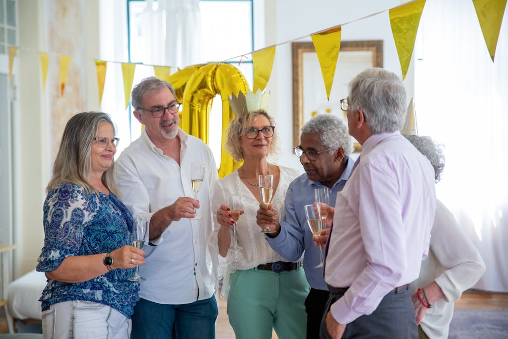 Ignoring These 10 Memory-Boosting Habits Could Speed Up Dementia in Seniors 1 A joyful gathering of senior friends celebrating with champagne indoors, featuring smiles and festive decor.