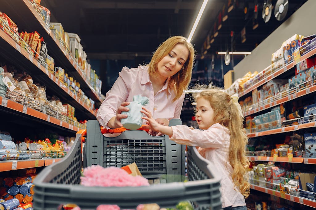 A mother and daughter shopping together in a supermarket aisle, enjoying quality time.