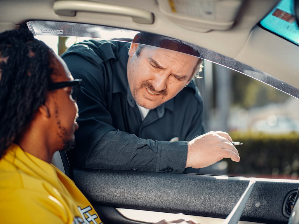 8 Mistakes You Should Never Make in America 1 A police officer interacts with a driver through a car window, emphasizing law enforcement and public safety.