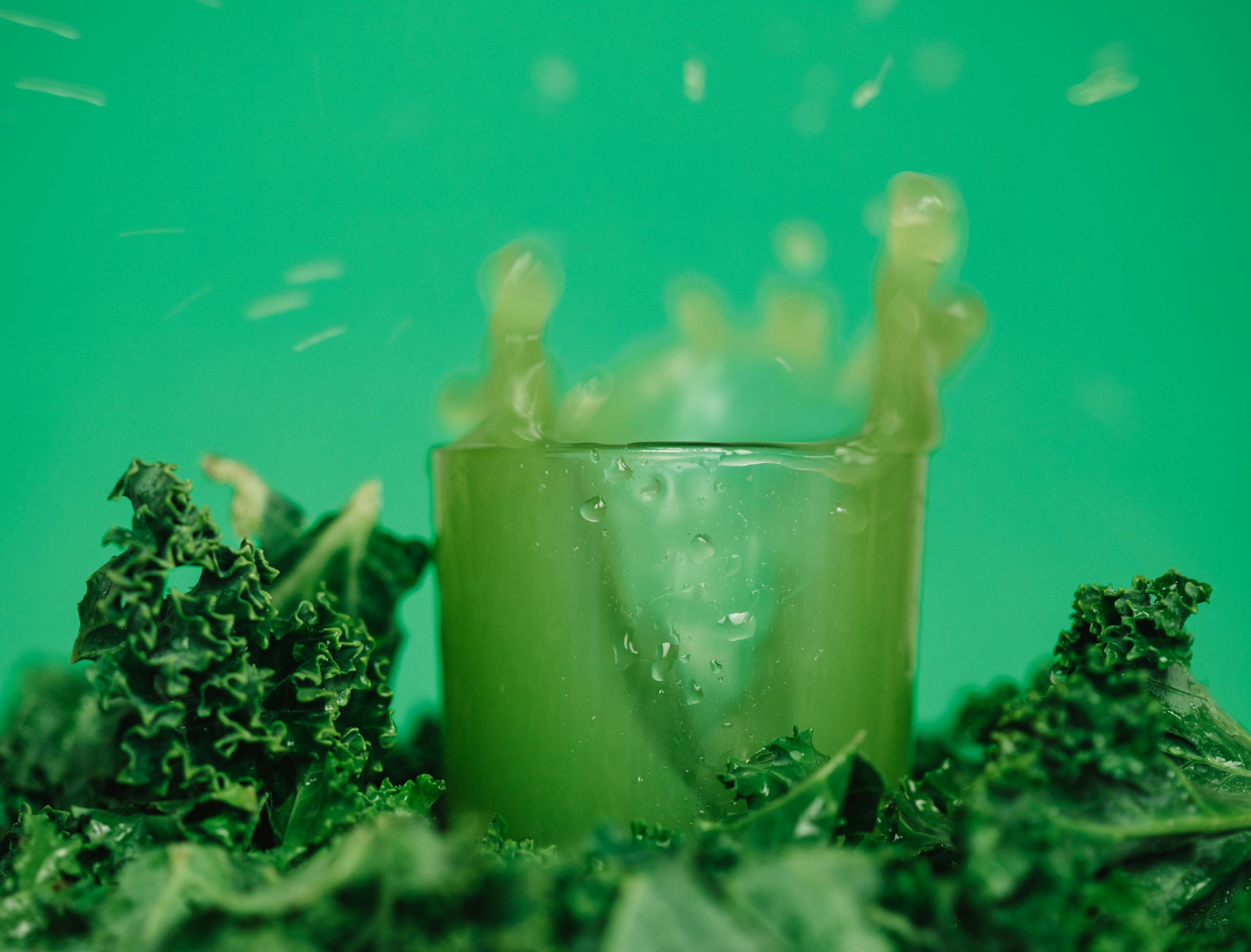 A refreshing kale juice splash showcasing vibrant and healthy lifestyle with green hues.