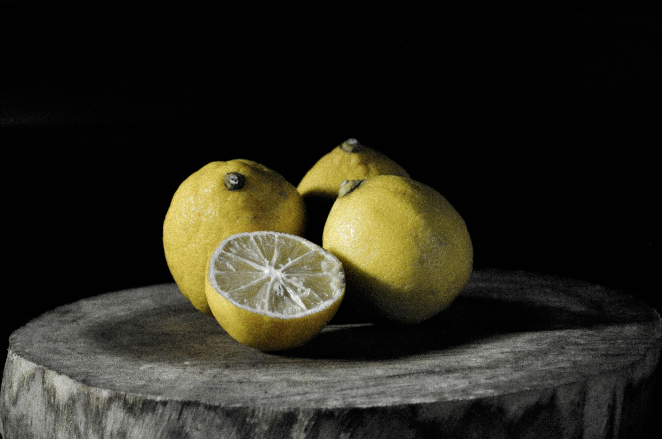 A rustic still life depicting fresh lemons on a wooden surface, enhancing their vibrant color.