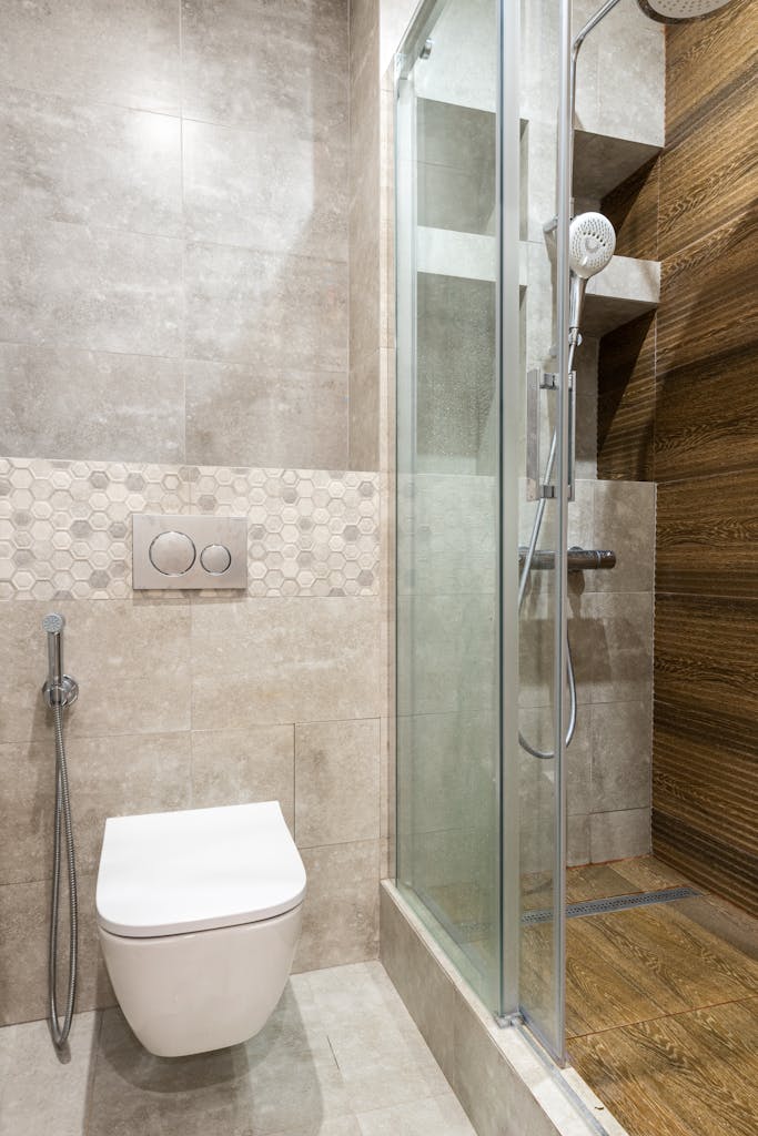 A sleek, modern bathroom featuring a shower stall and wall-mounted toilet.