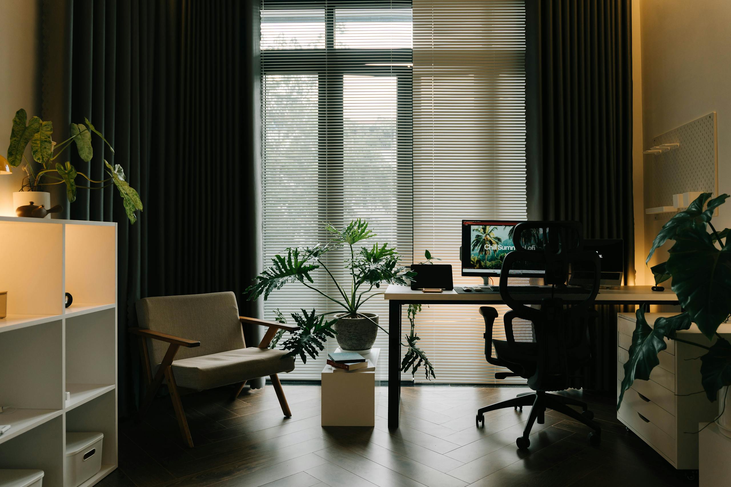 A stylish home office featuring indoor plants, natural light, and a modern workspace.