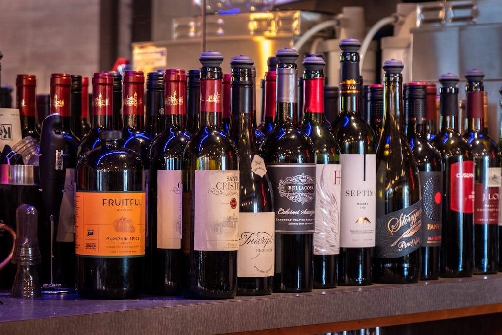 A variety of wine bottles elegantly displayed at a bar, including red, white, and sparkling wines.