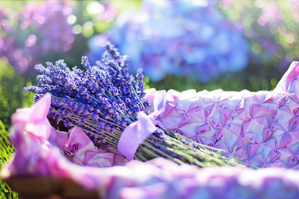A vibrant bouquet of lavender flowers nestled in a pink patterned basket outdoors.
