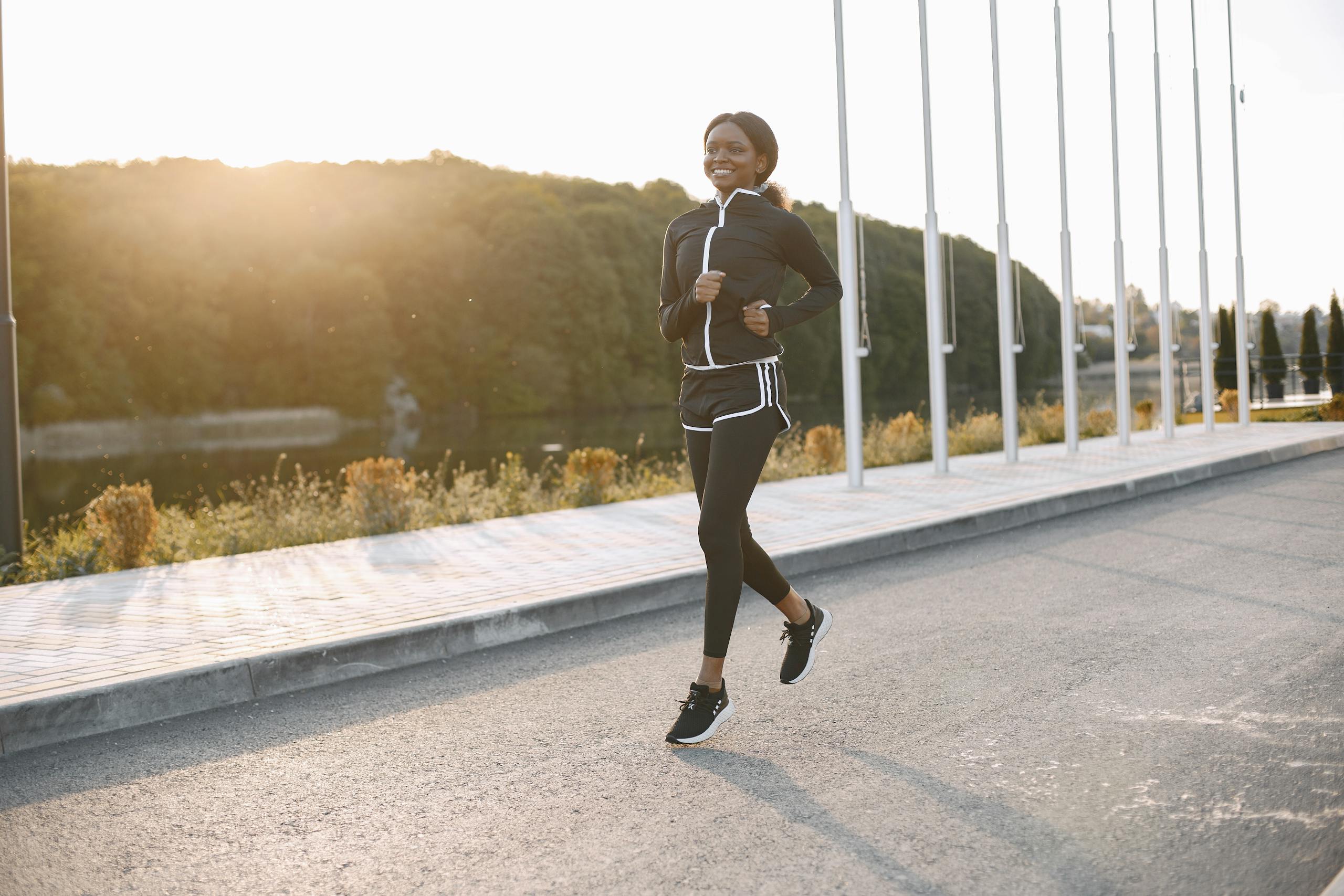 A woman jogging on a sunny outdoor path, showcasing fitness and sport.