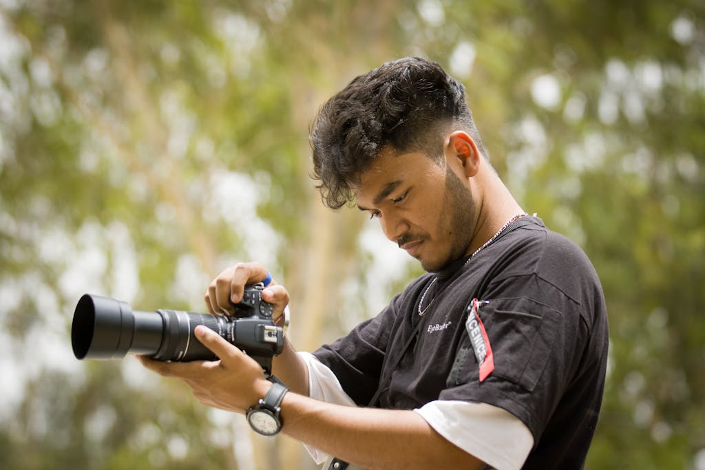 Skip These 8 Hobbies If You Want to Stay Burned Out 1 A young male photographer setting up his camera outdoors, focused and ready to capture the moment.