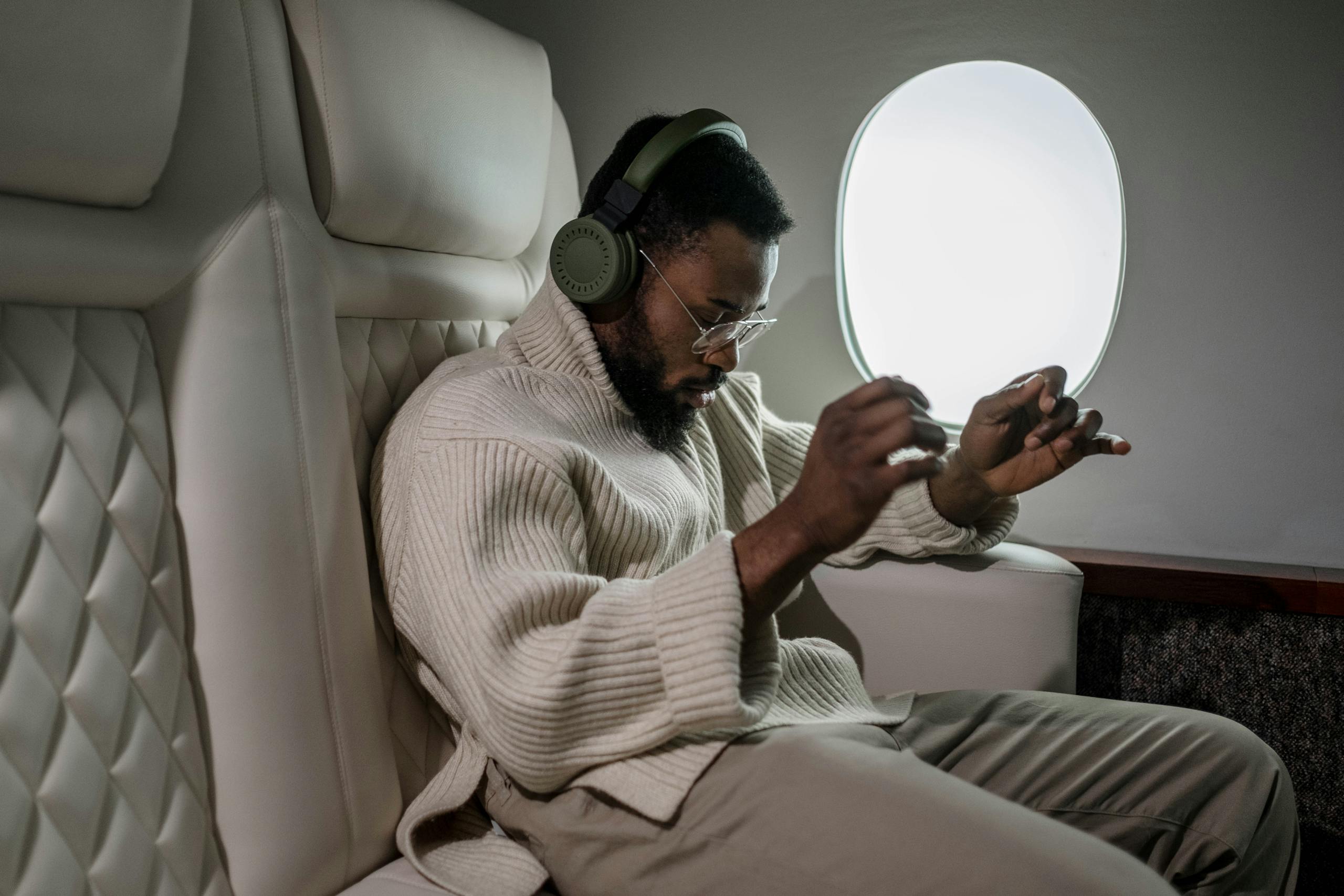 African American man enjoying music with headphones during a flight.