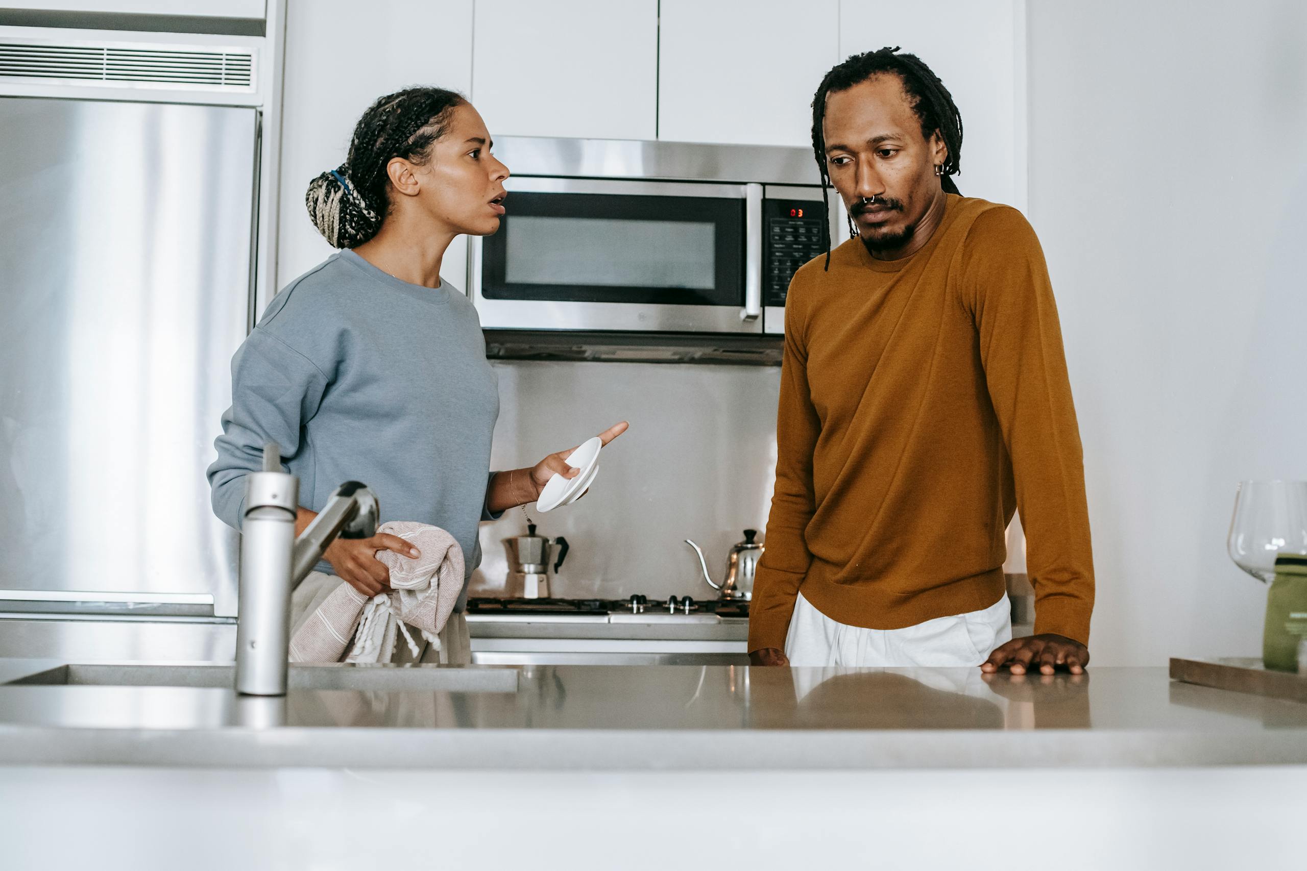 An african american couple engaged in a serious dialogue in their modern kitchen.