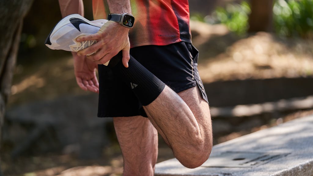 An athlete performs a stretching routine outdoors, highlighting fitness and healthy lifestyle.