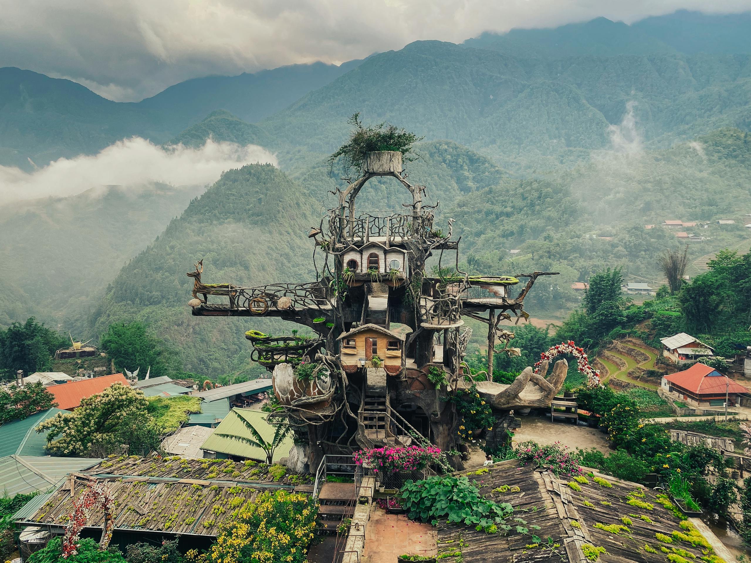 An enchanting and surreal architectural wonder amidst misty mountains and lush greenery.