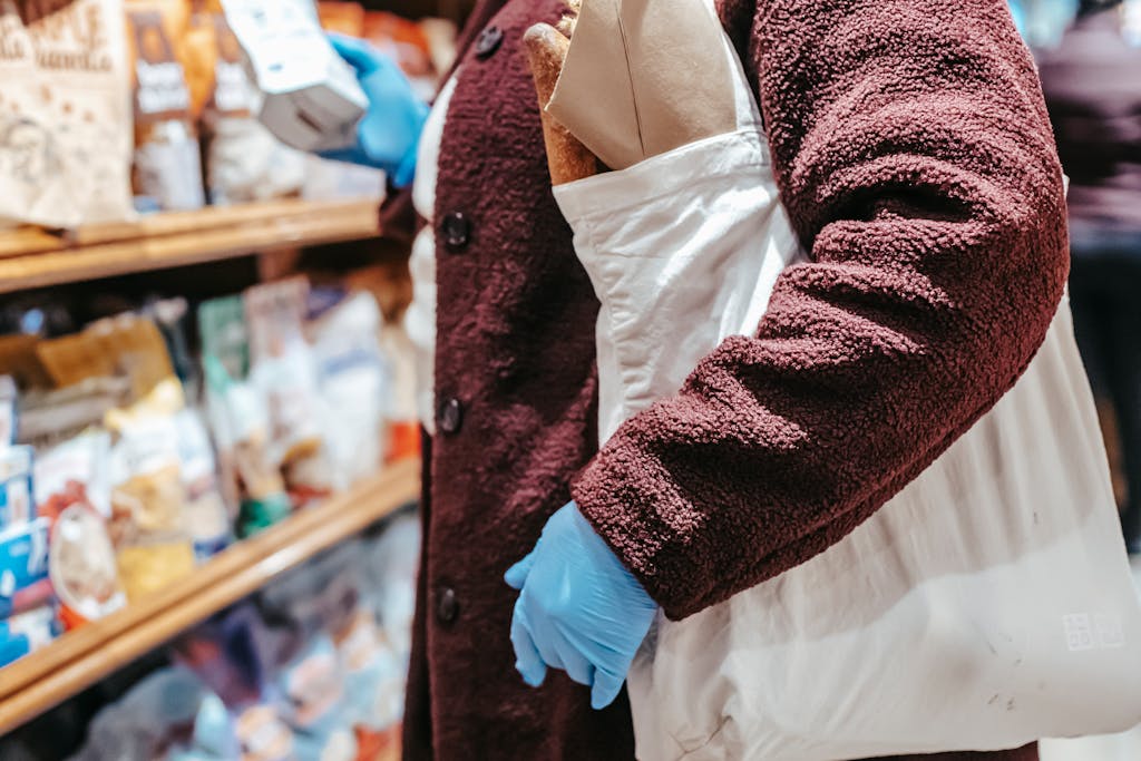 Anonymous woman shopping with a reusable bag in a grocery store, emphasizing sustainability.