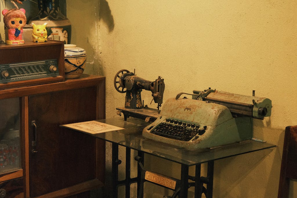 Antique sewing machine and typewriter in a nostalgic vintage room setting.
