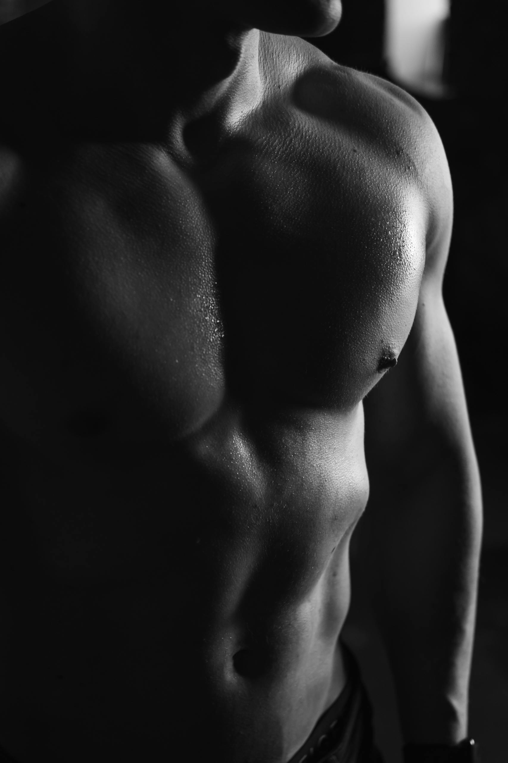 Close-up black and white photo of a muscular male torso. Perfect for fitness and health themes.