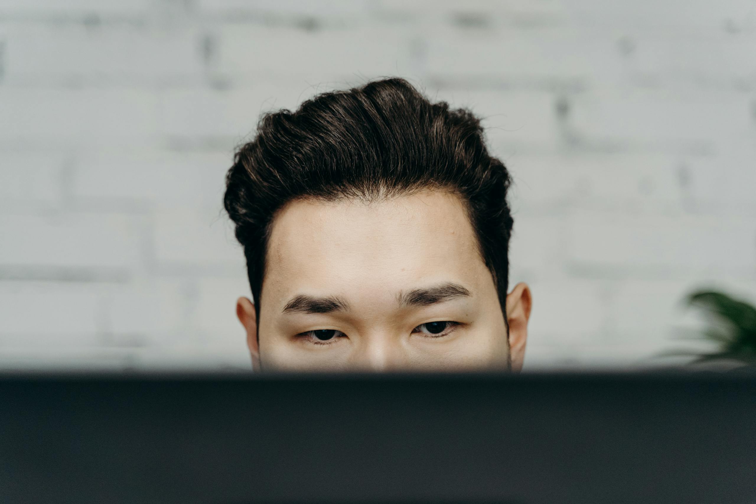 Close-up of a man intensely focused, working indoors in an office environment.