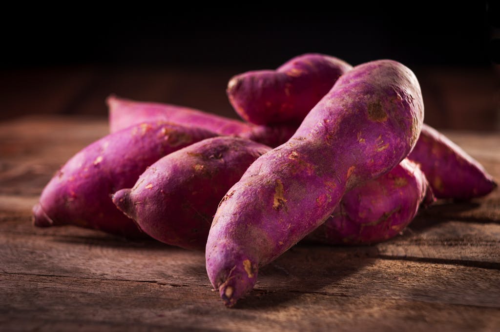 10 Superfoods That Could Be Damaging Your Health 1 Close-up of purple sweet potatoes on a wooden surface, perfect for culinary and natural food themes.